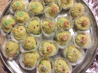 A tray of Burfi that has been piped instead of set in a large tray. Other decorations have been added, 